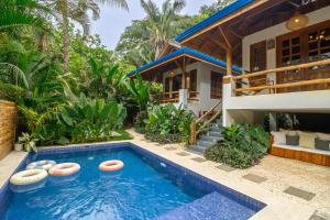 Villa con piscina frente a una casa en Blue Surf Sanctuary, en Santa Teresa Beach
