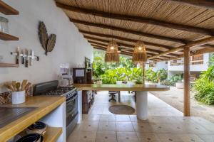 an outdoor kitchen with a table and a counter at Blue Surf Sanctuary in Santa Teresa Beach