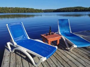 2 sillas y una mesa con una botella de vino en un muelle en Muskoka Shores Cottages, en Port Carling