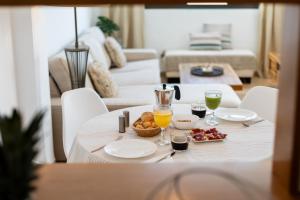 uma mesa com um prato de comida e dois copos de sumo de laranja em Ático con fantásticas vistas em Conil de la Frontera