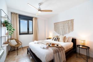 um quarto com uma grande cama branca e uma janela em Ático con fantásticas vistas em Conil de la Frontera