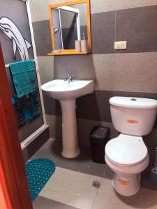 a small bathroom with a toilet and a sink at Kicker House in Puerto Baquerizo Moreno
