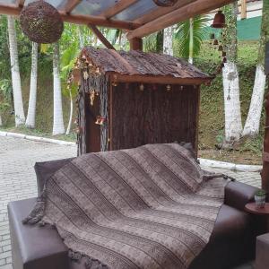 Una cama con una manta encima. en Sitio do Sol quarto wc compartilhado en Guabiruba