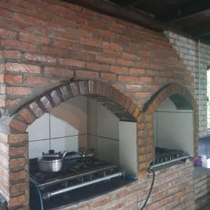 een bakstenen oven met een pot erop bij Sitio do Sol quarto wc compartilhado in Guabiruba