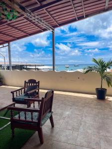 two benches on a patio with a view of the ocean at Kicker House in Puerto Baquerizo Moreno