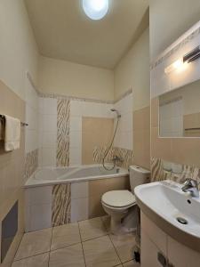 y baño con bañera, aseo y lavamanos. en Penzion pod Krivanom, en Liptovský Hrádok
