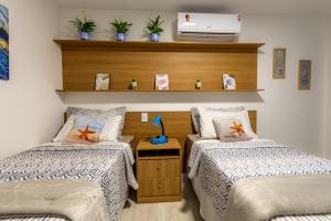 アハイアウ・ド・カボにあるCobertura Pé na Areia- Piscina, Churrasqueira, Vista Mar e a 50m da Praia dos Anjosのベッドルーム1室(ベッド2台、棚上のノートパソコン付) +67枚の写真