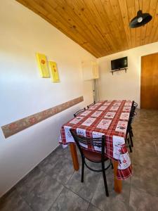 a dining room with a table and a tv at Cabañas Llitulun in Alpa Corral