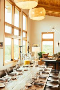 a large wooden table in a room with windows at The Lodge at 58* North in King Salmon