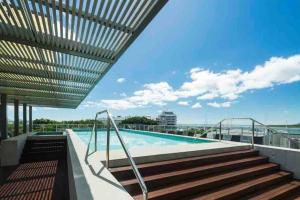 a swimming pool on the roof of a building at Oasis at Harbour lights Cairns in Cairns
