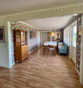comedor con mesa en una habitación con papel pintado en Idylliskt hus med sjöutsikt., en Östhammar