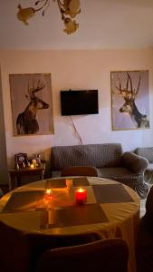 Petra Everest Hostel في ‘Ayn Amūn: غرفة معيشة مع أريكة وطاولة مع شمعة