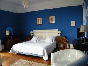a blue bedroom with a bed and a chair at Villa Les Iris in Saint-Félix