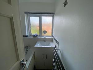 a bathroom with a sink and a window at Cosy 3BR Home Close to Villa Park Castle Bromwich off the M6 in Birmingham