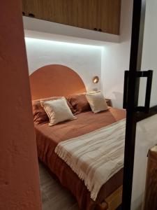 - une chambre avec un grand lit et une tête de lit en bois dans l'établissement Ossidiana Rossa Elegant Suite Vulcano, à Vulcano