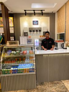 a man standing behind a counter in a store at زهرة الربيع للشقق المخدومة zahrat alrabie Hotel in Jeddah