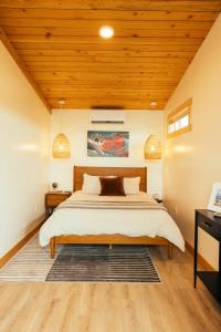 a bedroom with a bed and a wooden ceiling at The Lodge at 58* North in King Salmon