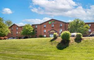 a large brick building with a lawn in front of it at Extended Stay America Select Suites - St Louis - Earth City in Earth City