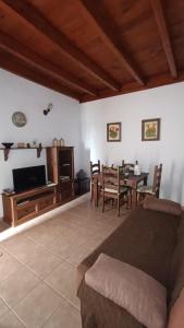 a living room with a table and a dining room at Casa Rural LUCÍA in Isora