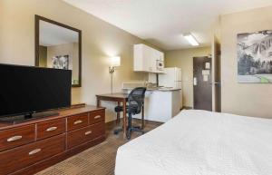 a hotel room with a bed and a flat screen tv at Extended Stay America Suites - Richmond - Hilltop Mall in Richmond