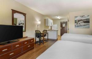 a hotel room with a bed and a flat screen tv at Extended Stay America Suites - Richmond - Hilltop Mall in Richmond