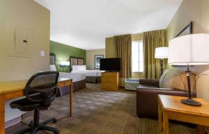 a hotel room with a desk and a room with two beds at Extended Stay America Suites - Phoenix - Scottsdale in Scottsdale