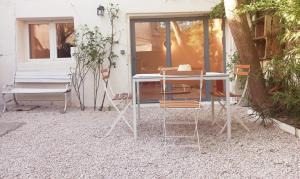 una mesa y sillas frente a una casa en Le Nid, en Aviñón