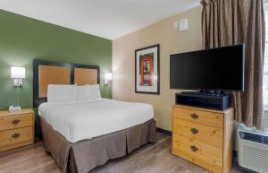 a hotel room with a bed and a flat screen tv at Extended Stay America Suites - Pleasanton - Chabot Dr in Pleasanton
