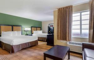 a hotel room with two beds and a couch at Extended Stay America Suites - Pleasanton - Chabot Dr in Pleasanton