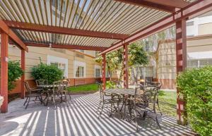 a patio with tables and chairs under a wooden pergola at Extended Stay America Suites - Pleasanton - Chabot Dr in Pleasanton