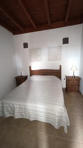 a bedroom with a large bed and two night stands at Casa Rural LUCÍA in Isora