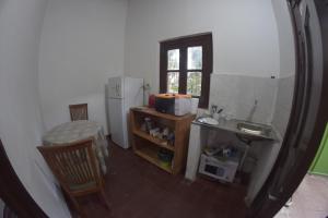 una pequeña cocina con fregadero y nevera. en Hotel La Mansión, en Villarrica