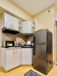 a kitchen with a stainless steel refrigerator and white cabinets at * *Q Incomparable Comfort for 3 in Iloilo City +6 photos
