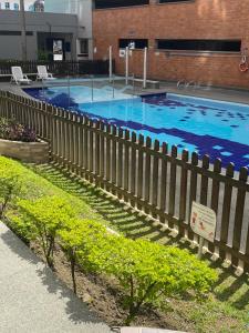 una gran piscina con una valla de madera en La Sabana, en Sabaneta