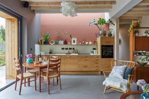 kuchnia ze stołem i krzesłami w pokoju w obiekcie Nuthatch Retreat - Modern rustic ecohome with views w mieście Blakeney