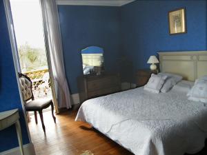 a blue bedroom with a bed and a chair at Villa Les Iris in Saint-Félix