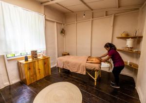 Eine Frau, die einen Mann auf einem Bett in einem Zimmer vorbereitet. in der Unterkunft Earth Lodge in Antigua Guatemala
