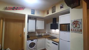 a kitchen with a white refrigerator and a washer at El Cielo de Escarrilla in Escarrilla