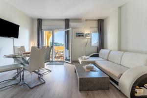 een woonkamer met een bank en een tafel bij Beachfront Puerto Cabopino in Marbella