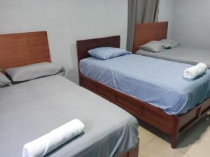 - 2 lits jumeaux dans une chambre avec des serviettes dans l'établissement Hotel Albatros, à Isla Aguada