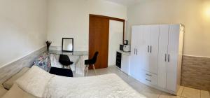 1 dormitorio con escritorio y armario blanco en TERRAÇO DA BARRA, en Florianópolis