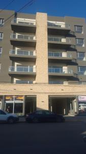 two cars parked in front of a building at Amplio Estudio de lujo con balcon y parrilla in Puerto Madryn