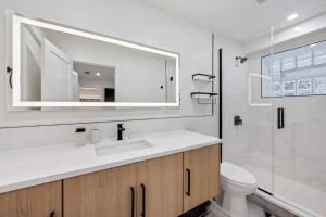 a bathroom with a sink and a toilet and a mirror at Logan Square Luxury Villa, 3 Beds, 3 Baths in Chicago