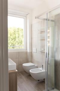 baño con lavabo y aseo y ventana en Van Gogh Exclusive Apartment, en Milán