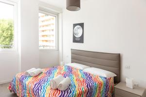 1 dormitorio con 1 cama colorida y toallas. en Van Gogh Exclusive Apartment, en Milán
