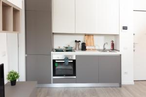 cocina con armarios blancos y horno en Van Gogh Exclusive Apartment, en Milán