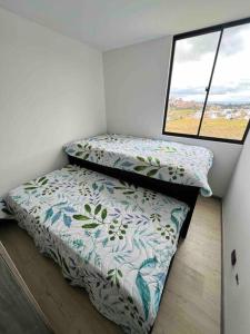 ein kleines Schlafzimmer mit 2 Betten und einem Fenster in der Unterkunft Nuevo Apartamento frente al Centro Comercial VIVA in Tunja