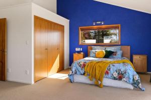a bedroom with a blue wall and a bed at The Terrace Lake Tarawera in Lake Tarawera