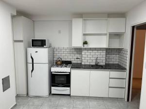 a kitchen with white cabinets and a refrigerator at Departamento céntrico-46 n 326 entre1y2 in La Plata