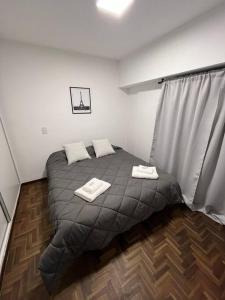 a bedroom with a bed with two towels on it at Departamento céntrico-46 n 326 entre1y2 in La Plata +6 photos